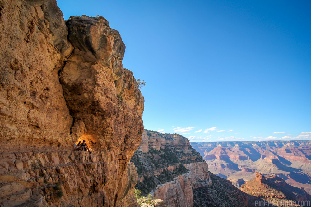 two people sitting in a window in the inner rim of the Grand Canyon in Arizona