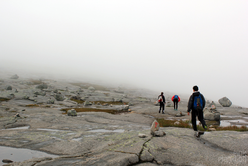 hikers in rocky cloudy scenery in Norway
