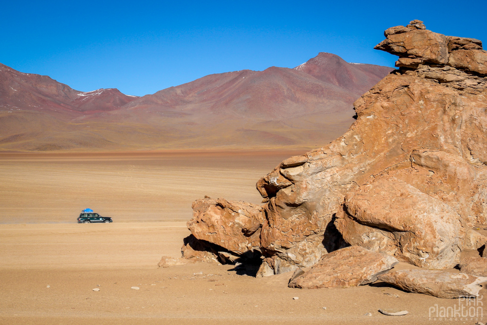 jeep and rock formations in Bolivia's desert