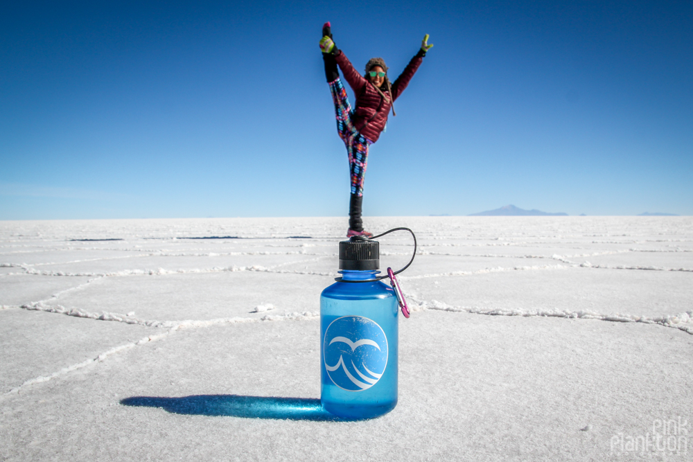 person doing Y stand on top of Nalgene bottle on Bolivia's Salar de Uyuni