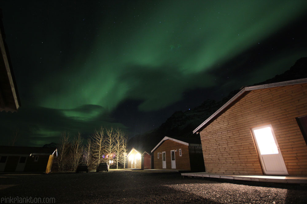 Northern Lights/aurora borealis over cabins in Iceland