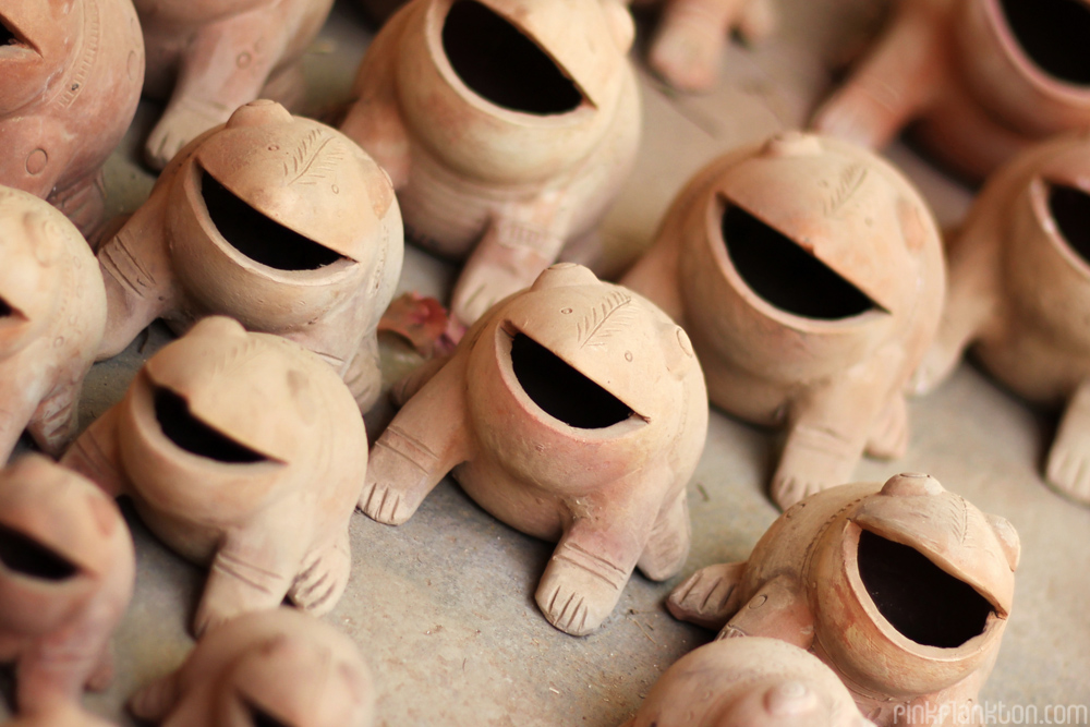 rows of clay frog figurines in market