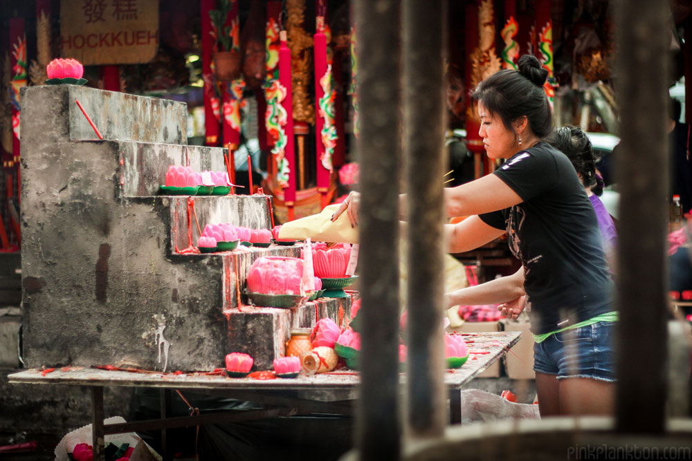 Chinese New Year woman lighting candle in temple