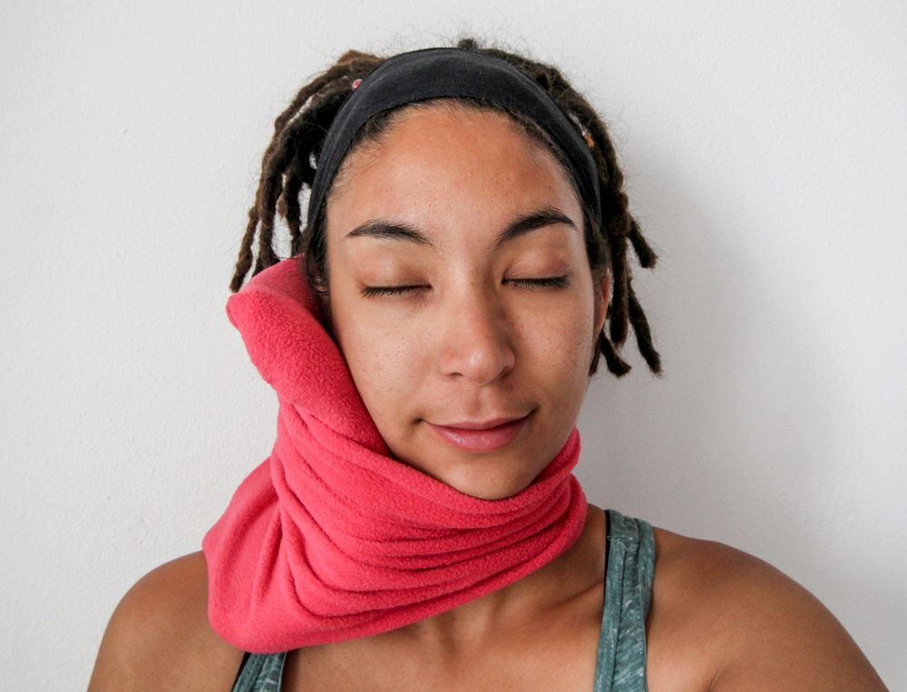 Woman wearing Trtl travel pillow