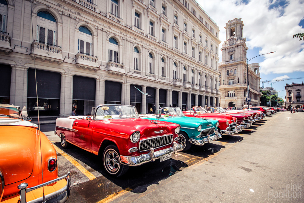 colorful classic cars in Havana Cuba in front of colonial architectural building