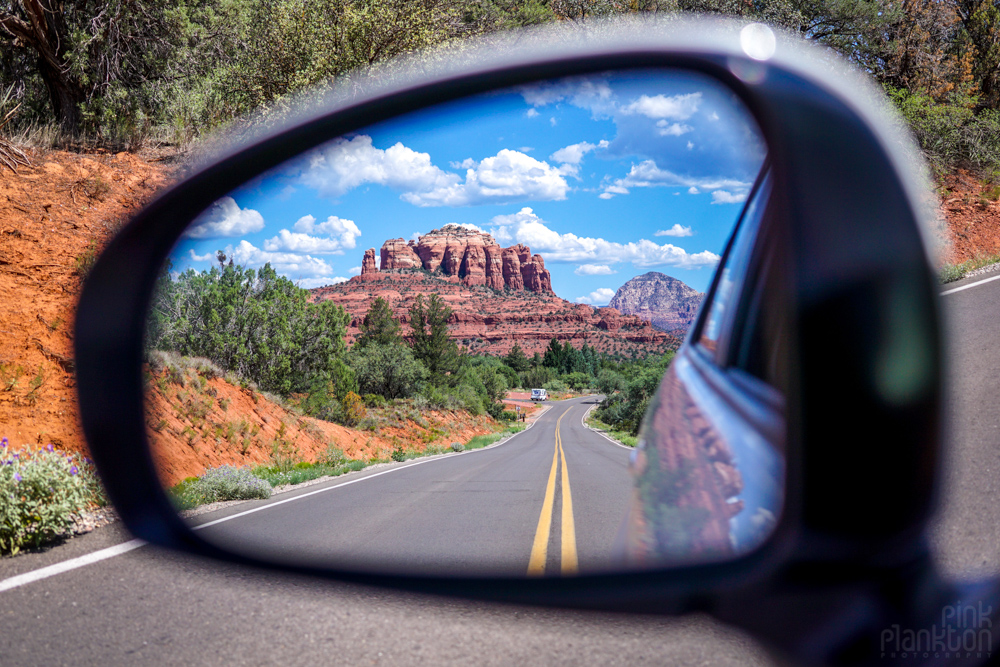 road and red rocks of Sedona in car mirror