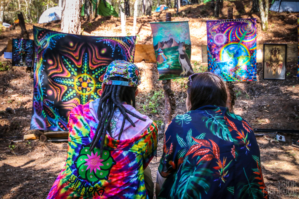 2 people sitting in visionary art gallery at Festival Psycristrance
