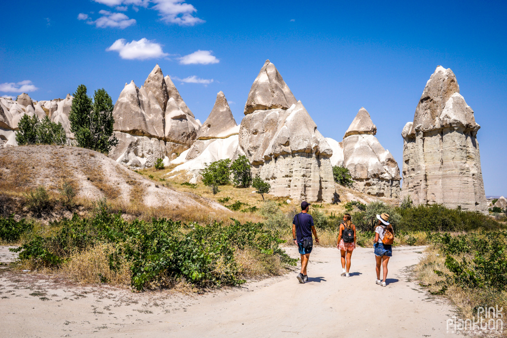 three hikers hiking through the penis-shaped rocks in Love Valley in Cappadocia, Turkey