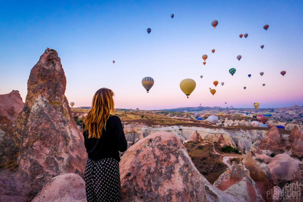 Girl looking at hot air balloons at sunrise in Cappadocia, Turkey