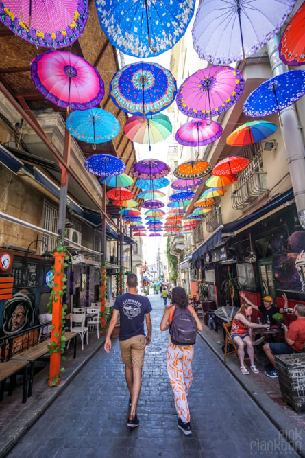 Couple walking under umbrella street in Karakoy, Istanbul