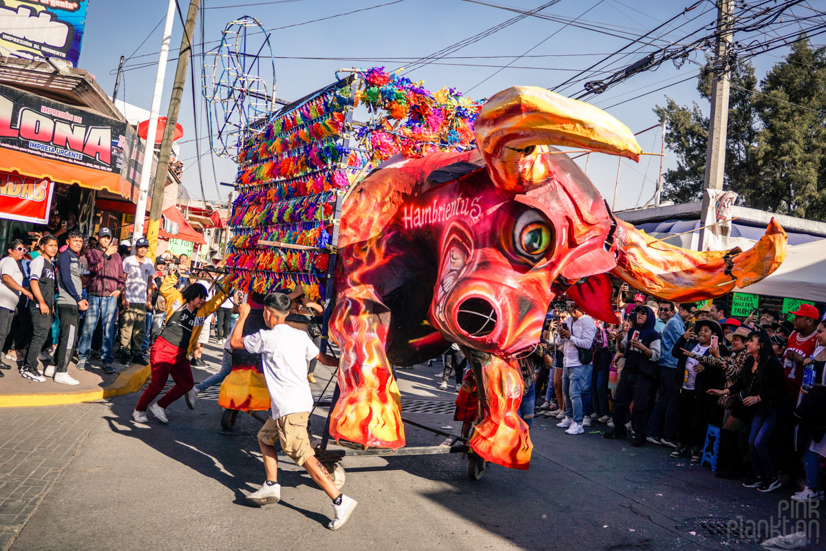 People turning a giant bull in the daytime at the Bulls of Fire Festival in Mexico