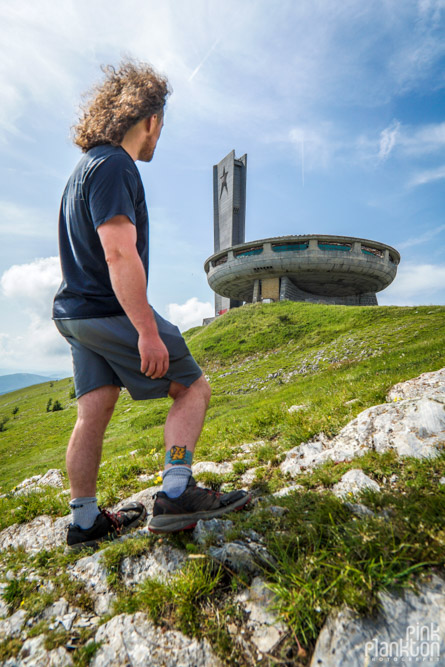 Man standing with Buzludzha abandoned Communist monument in background