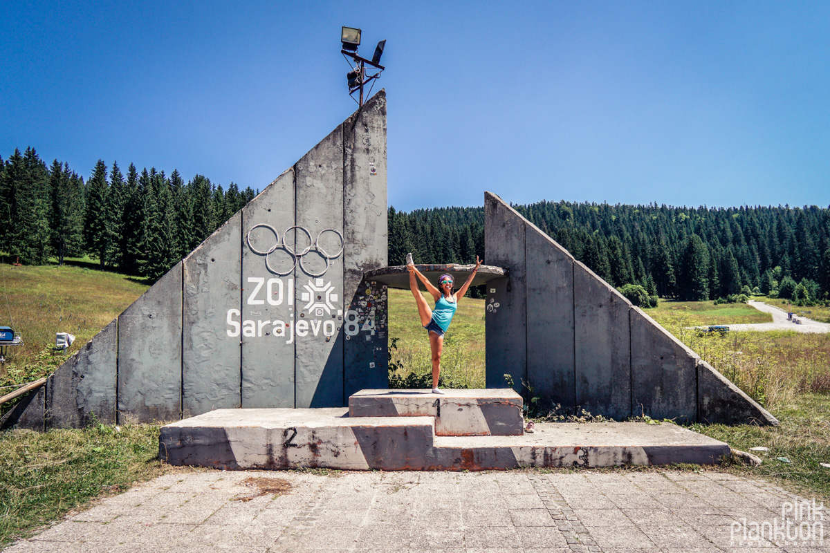 Girl doing yoga pose on abandoned Sarajevo Olympics podium at ski slope